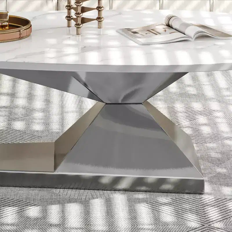 Table basse avec plateau en céramique et base contemporaine en acier inoxydable, une pièce maîtresse durable et élégante pour le salon.